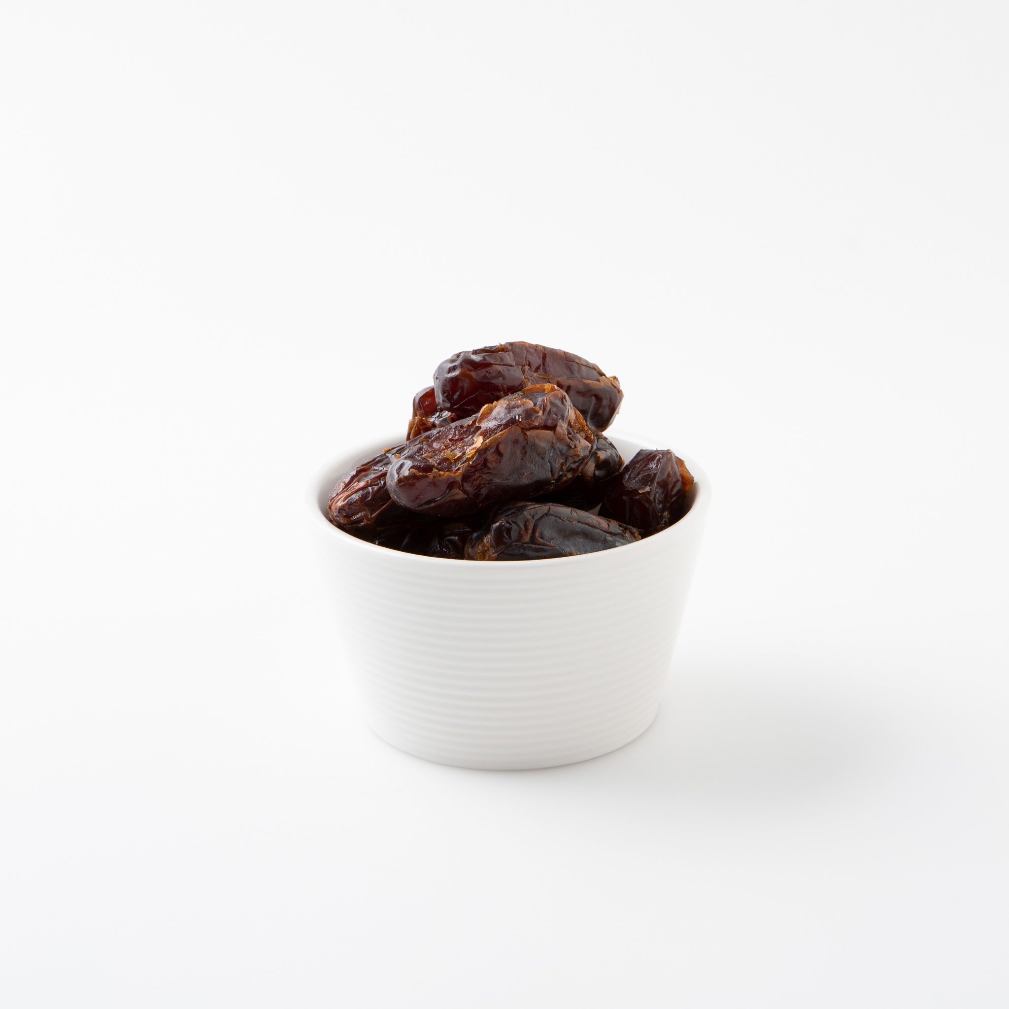 Organic Medjool Dates (Dried Fruits) in small white bowl - Naked Foods
