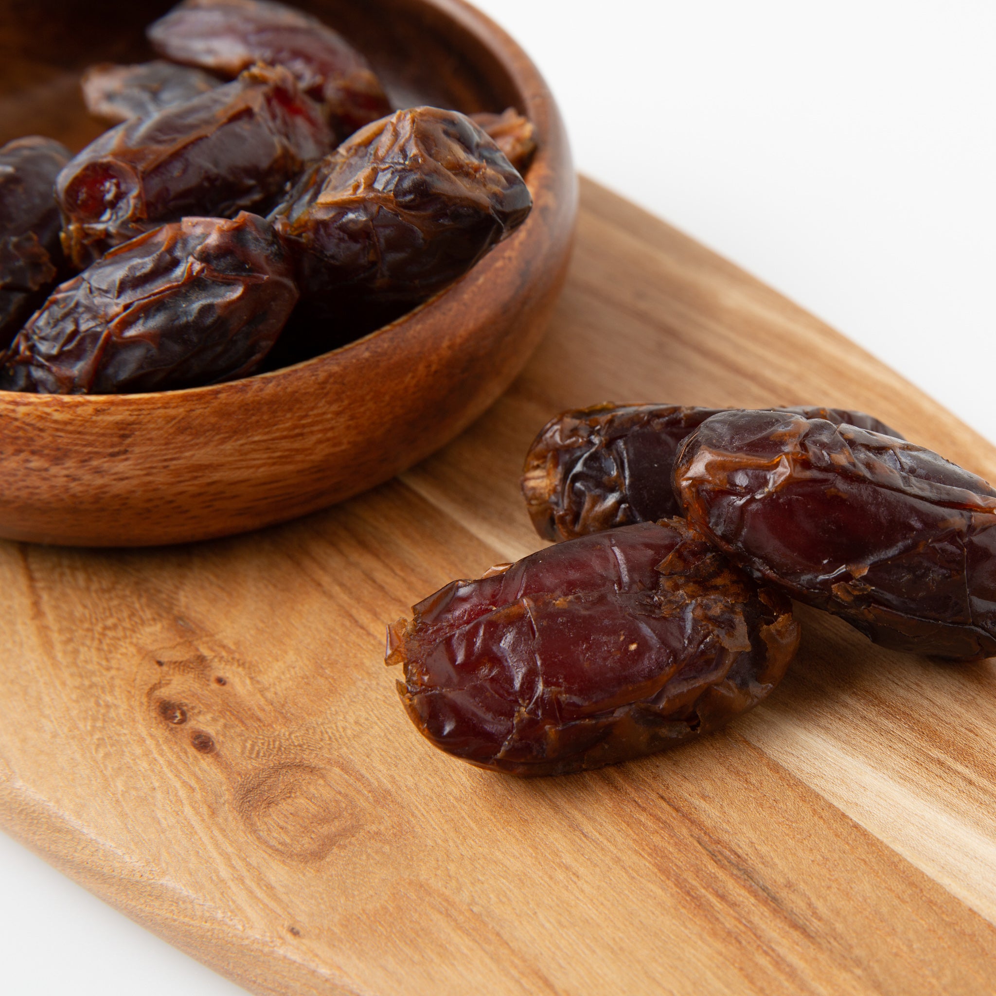 Organic Medjool Dates (Dried Fruits) in wooden serving board and bowl - Naked Foods