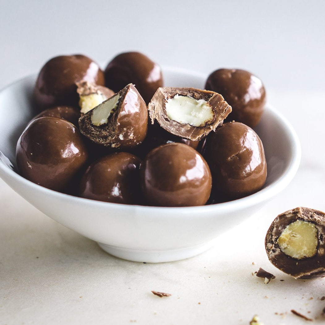 Tasty Milk Chocolate Macadamias (Chocolates) in small white bowl - Naked Foods
