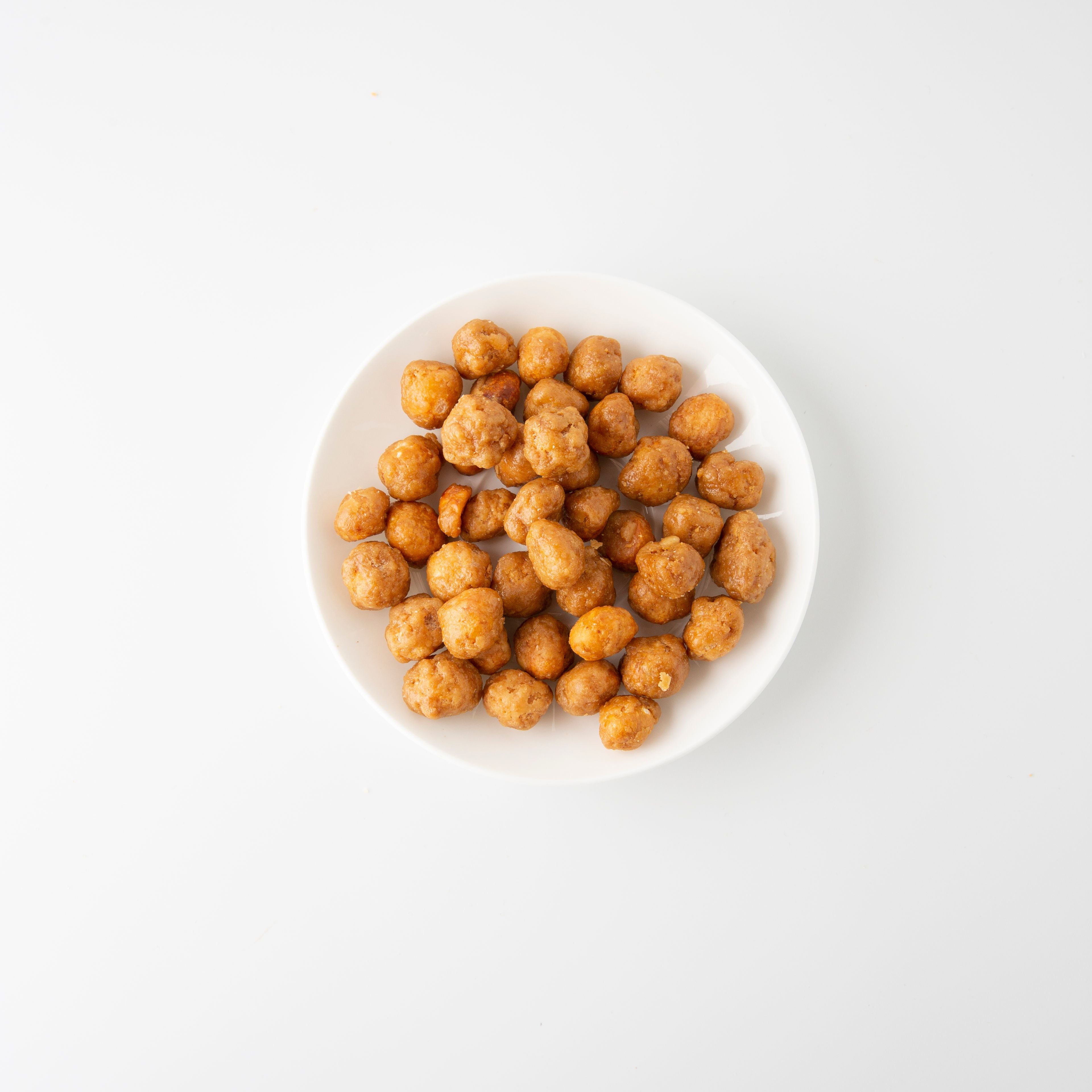 Roasted Honey Macadamia (Roasted Nuts) in white bowl - Naked Foods